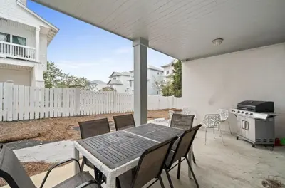 a patio with a table and chairs and a stove at Know When To Hold Em in Inlet Beach in Inlet Beach