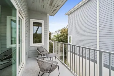 a porch with a chair and a stool on a house at Know When To Hold Em in Inlet Beach in Inlet Beach
