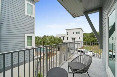 a balcony with a table and a chair at Know When To Hold Em in Inlet Beach in Inlet Beach