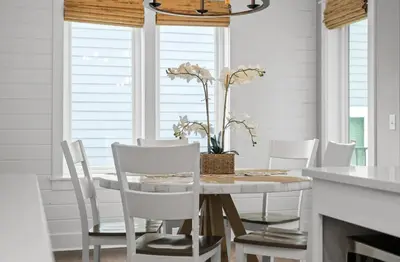 a dining room with a white table and white chairs at Know When To Hold Em in Inlet Beach in Inlet Beach