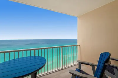 a balcony with a blue table and chairs and the ocean at Majestic Beach Towers 2-1703 by Emerald Coast Retreats in Panama City Beach