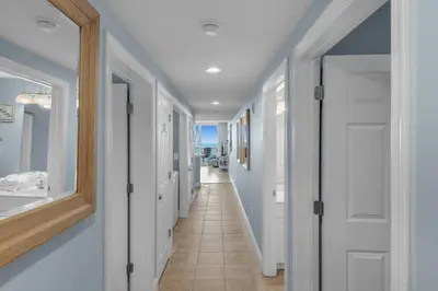a hallway with white doors and a tile floor at Majestic Beach Towers 2-1703 by Emerald Coast Retreats in Panama City Beach