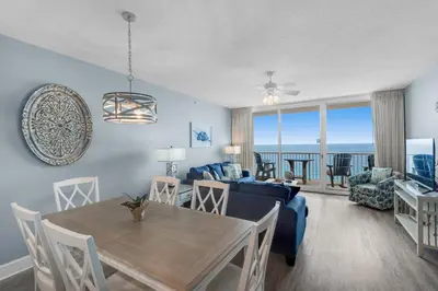 a living room with a table and a blue couch at Majestic Beach Towers 2-1703 by Emerald Coast Retreats in Panama City Beach