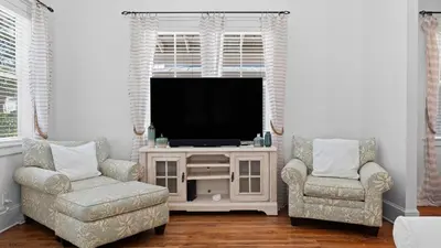 a living room with two chairs and a television at Serene 30A Getaway Steps from the Gulf with BBQ Wraparound Porch 30A Fade Away by AvantStay in Santa Rosa Beach