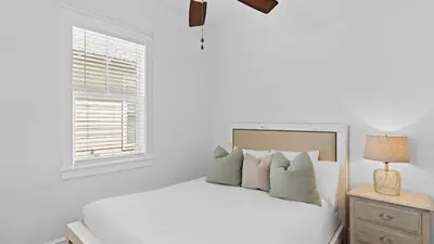 a white bedroom with a bed and a window at Serene 30A Getaway Steps from the Gulf with BBQ Wraparound Porch 30A Fade Away by AvantStay in Santa Rosa Beach
