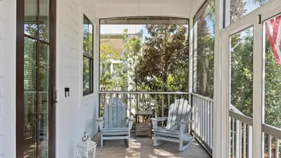 two chairs on a screened porch with windows at Serene 30A Getaway Steps from the Gulf with BBQ Wraparound Porch 30A Fade Away by AvantStay in Santa Rosa Beach