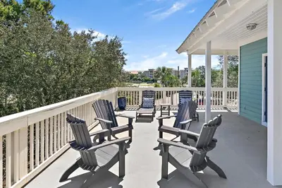a row of chairs sitting on a porch at Geauxing Coastal 10 ppl 3 BR 3BA Bikes Community pool 5 Min walk to the beach in Seacrest