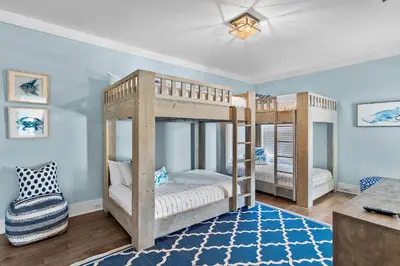 two bunk beds in a room with a couch at Geauxing Coastal 10 ppl 3 BR 3BA Bikes Community pool 5 Min walk to the beach in Seacrest