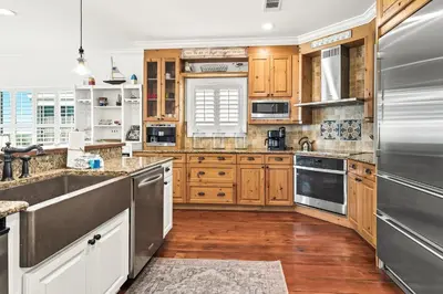 a kitchen with wooden cabinets and stainless steel appliances at 4 BR GULF Front Condo, Bikes, & Community Pool in Seagrove Beach