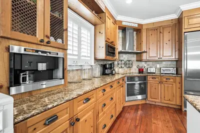 a kitchen with wooden cabinets and stainless steel appliances at 4 BR GULF Front Condo, Bikes, & Community Pool in Seagrove Beach