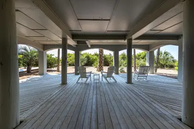 a porch with chairs and a table on it at 4 BR GULF Front Condo, Bikes, & Community Pool in Seagrove Beach