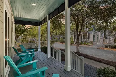 a porch with blue chairs on a house at NEW! Fall Break OPEN 4 BR, Pool, Bikes & close to shopping & beach in Seagrove Beach