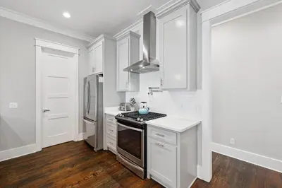 a kitchen with white cabinets and a stove top oven at NEW! Fall Break OPEN 4 BR, Pool, Bikes & close to shopping & beach in Seagrove Beach