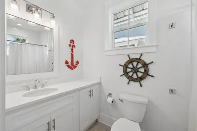 a bathroom with a sink and a toilet and a wheel on the wall at NEW! Fall Break OPEN 4 BR, Pool, Bikes & close to shopping & beach in Seagrove Beach