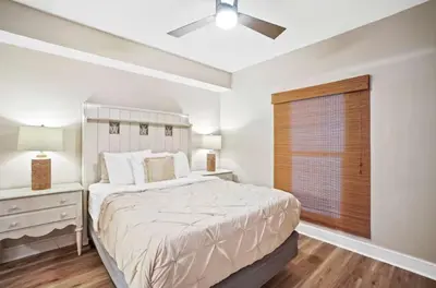 a white bedroom with a bed and a window at Majestic Beach Towers 1-1903 by Emerald Coast Rereats in Panama City Beach