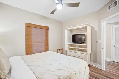 a white bedroom with a bed and a tv at Majestic Beach Towers 1-1903 by Emerald Coast Rereats in Panama City Beach
