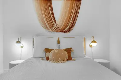 a white bed with a teddy bear sitting on it at 30a Seagrove Beach Condo with Gulf & Lake Views in Santa Rosa Beach