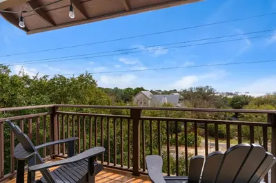 a deck with chairs and a view of a house at 30a Seagrove Beach Condo with Gulf & Lake Views in Santa Rosa Beach