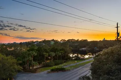 an empty road with a sunset in the background at 30a Seagrove Beach Condo with Gulf & Lake Views in Santa Rosa Beach