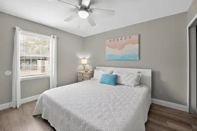 a white bedroom with a bed and a ceiling fan at Luxury Beach Access in Panama City Beach