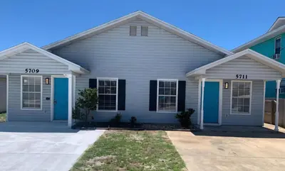 a white house with blue doors at Luxury Beach Access in Panama City Beach