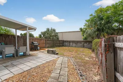 a backyard with a fence and a grill at Luxury Beach Access in Panama City Beach