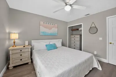 a bedroom with a white bed with a blue pillow at Luxury Beach Access in Panama City Beach
