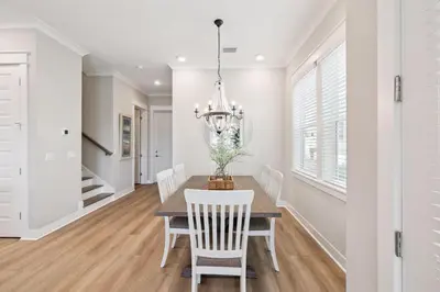 a dining room with a table and chairs and a chandelier at 30A All Day 88 E Pine Lands Loop Unit A in Inlet Beach