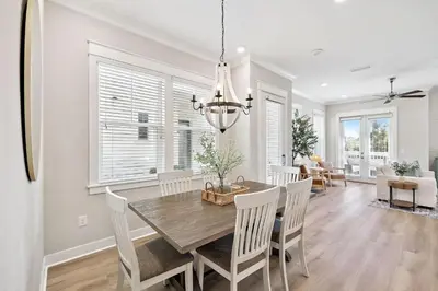 a dining room and living room with a table and chairs at 30A All Day 88 E Pine Lands Loop Unit A in Inlet Beach