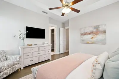 a bedroom with a ceiling fan and a tv at 30A All Day 88 E Pine Lands Loop Unit A in Inlet Beach