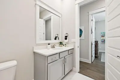 a white bathroom with a sink and a mirror at 30A All Day 88 E Pine Lands Loop Unit A in Inlet Beach