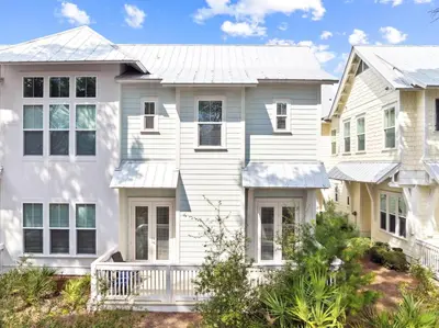 a large white house with a white porch at 30A All Day 88 E Pine Lands Loop Unit A in Inlet Beach