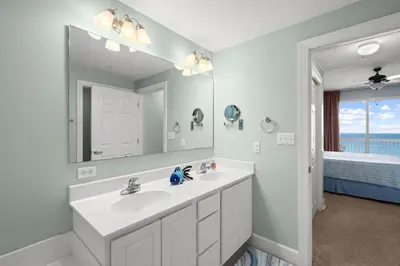 a white bathroom with a sink and a mirror at Music City Flamingo at Sunrise Beach Resort #705 by Nautical Properties in Panama City Beach