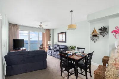 a living room with a couch and a table at Music City Flamingo at Sunrise Beach Resort #705 by Nautical Properties in Panama City Beach