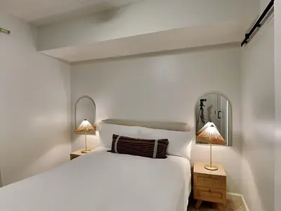 a white bedroom with a white bed and two lamps at Seychelles #402 in Panama City Beach