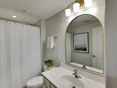 a white bathroom with a sink and a mirror at Seychelles #402 in Panama City Beach