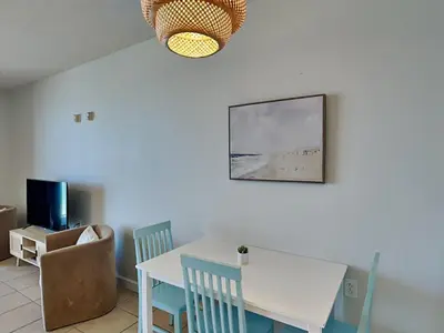 a dining room with a white table and chairs at Seychelles #402 in Panama City Beach