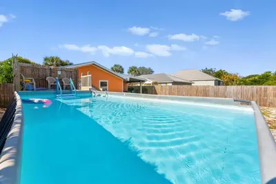 a large swimming pool in a backyard at Sunset Ave Beach House - Golf Cart, Pool, Hot Tub in Panama City Beach