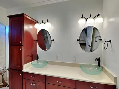 a bathroom with two sinks and two mirrors at Lazy River Retreat in Panama City Beach