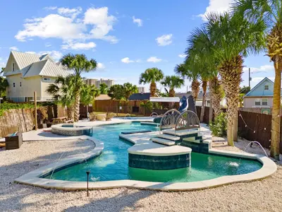 a swimming pool in a yard with palm trees at Lazy River Retreat in Panama City Beach