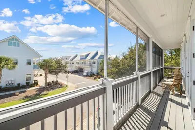 a view from the porch of a home with large windows at Sun and Sand for 6 - 167 Milestone Dr Unit C in Inlet Beach