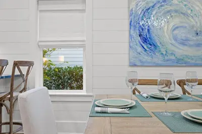 a dining room with a table with wine glasses at Sea D’Light: 3BR Beach Home Sleeps 10 with 4 Bikes in Watersound West in Santa Rosa Beach