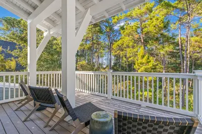 a porch with two chairs and a table at Sea D’Light: 3BR Beach Home Sleeps 10 with 4 Bikes in Watersound West in Santa Rosa Beach