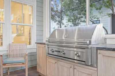 a grill in a kitchen with a chair and a window at Sea D’Light: 3BR Beach Home Sleeps 10 with 4 Bikes in Watersound West in Santa Rosa Beach