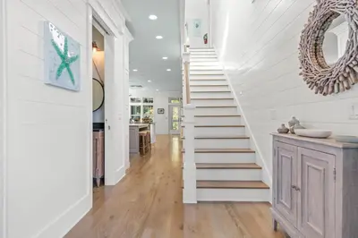 a staircase in a home with white walls and wood floors at Sea D’Light: 3BR Beach Home Sleeps 10 with 4 Bikes in Watersound West in Santa Rosa Beach