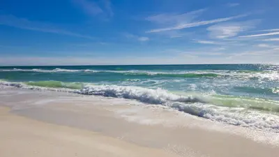 a beach with the ocean and the waves at Sea D’Light: 3BR Beach Home Sleeps 10 with 4 Bikes in Watersound West in Santa Rosa Beach