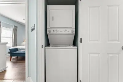 a washer and dryer in a room with a door at Beach Resort Condo with 5 Pools! Steps to Beach! by Dolce Vita Getaways PCB in Panama City Beach