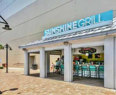 a sun shine grill sign on the side of a building at Beach Resort Condo with 5 Pools! Steps to Beach! by Dolce Vita Getaways PCB in Panama City Beach
