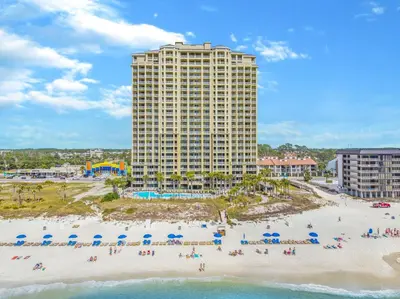 a view of a beach with umbrellas and a building at Grand Panama Beach Resort - Pet Friendly Condos by Panhandle Getaways in Panama City Beach