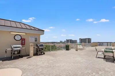 a patio with a clock on the side of a building at Grand Panama Beach Resort - Pet Friendly Condos by Panhandle Getaways in Panama City Beach